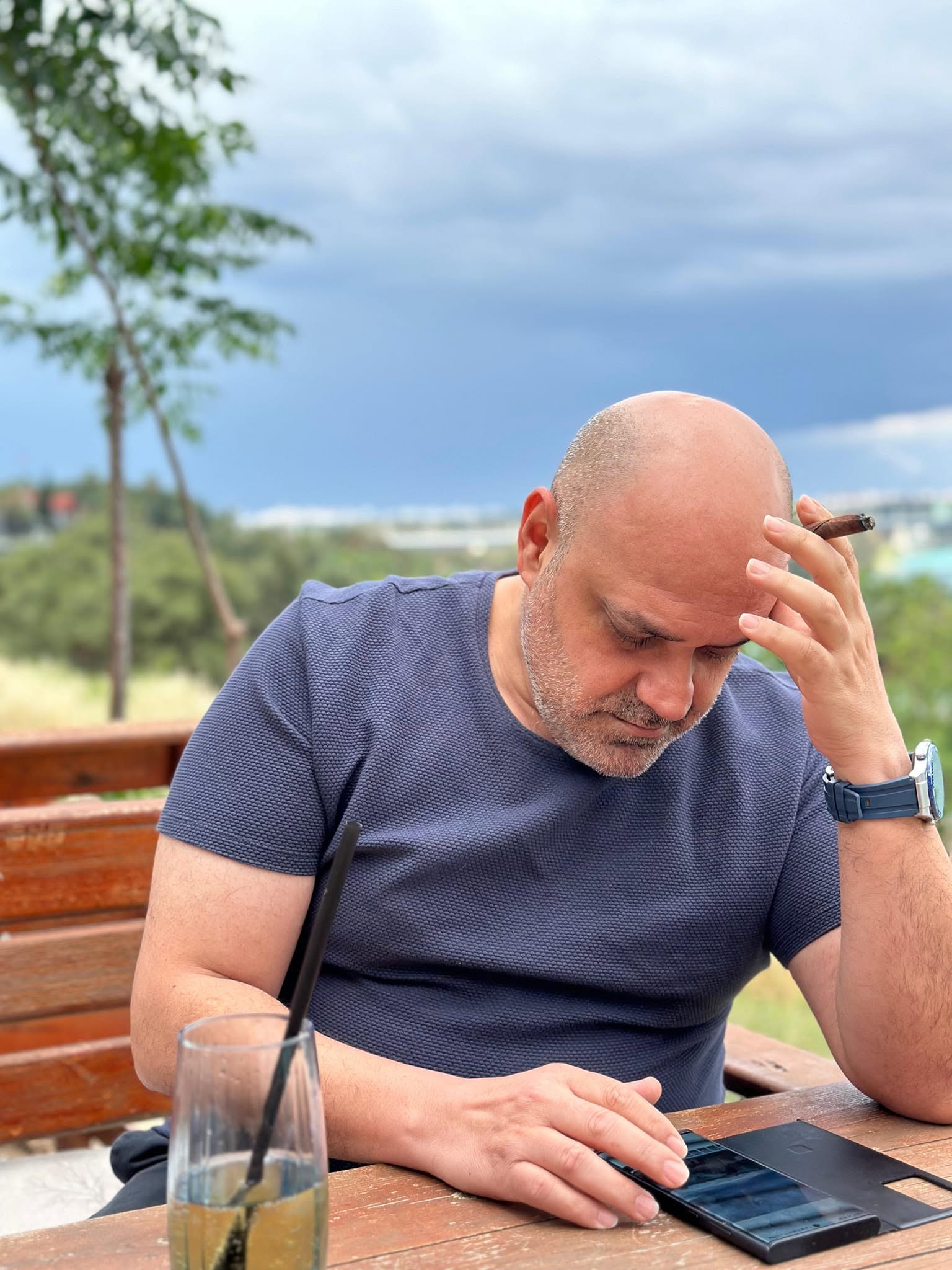 Açık havada masa başında tabletine bakan Hakan Düzenli.