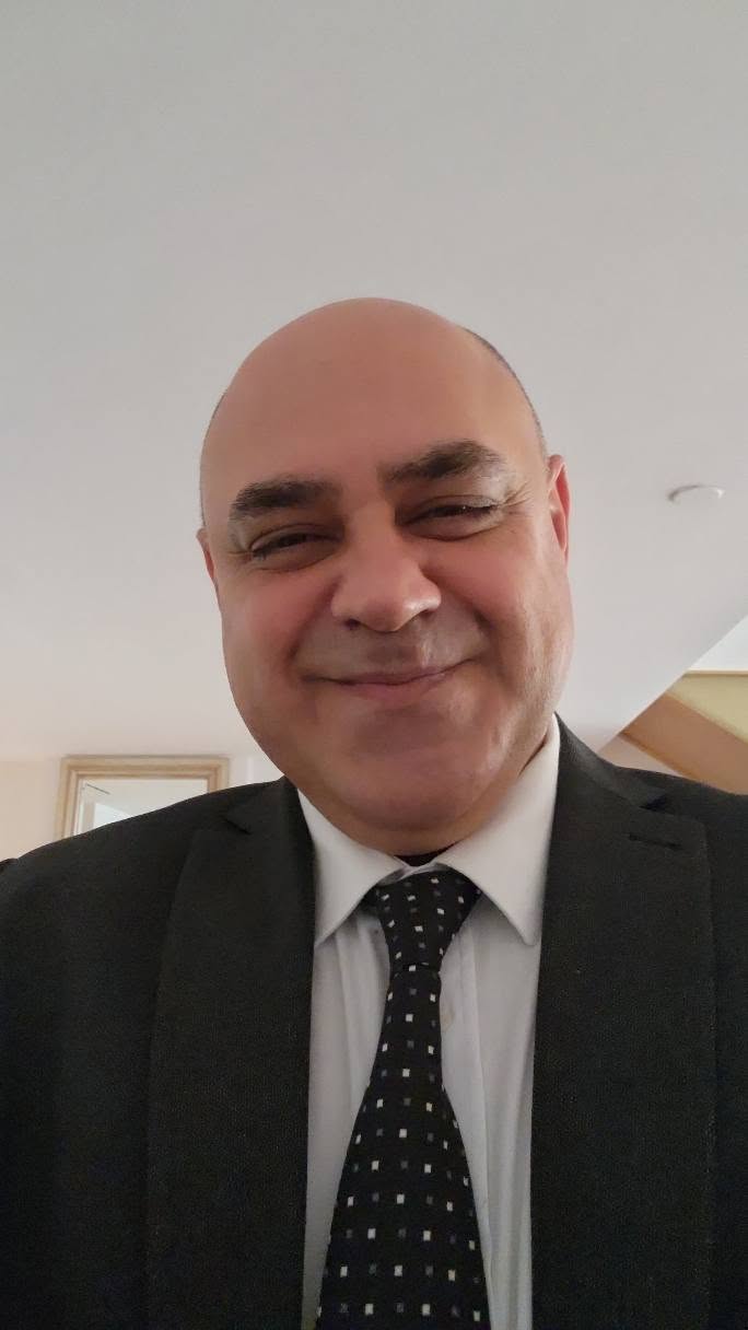 Takım elbiseli ve kravatlı Hakan Düzenli’nin portresi.